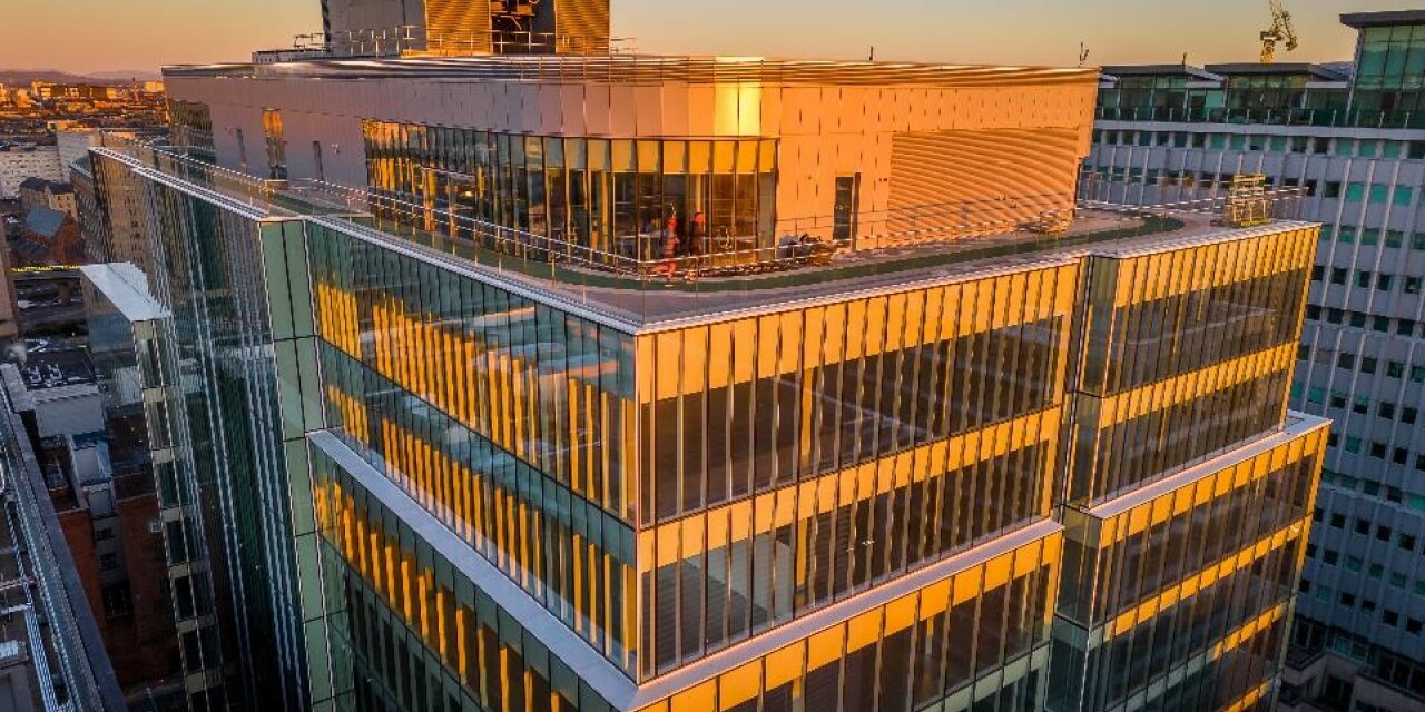 Two runners on the rooftop running track of 177 Bothwell Street at sunrise