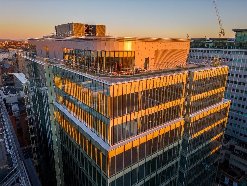 Two runners on the rooftop running track of 177 Bothwell Street at sunrise